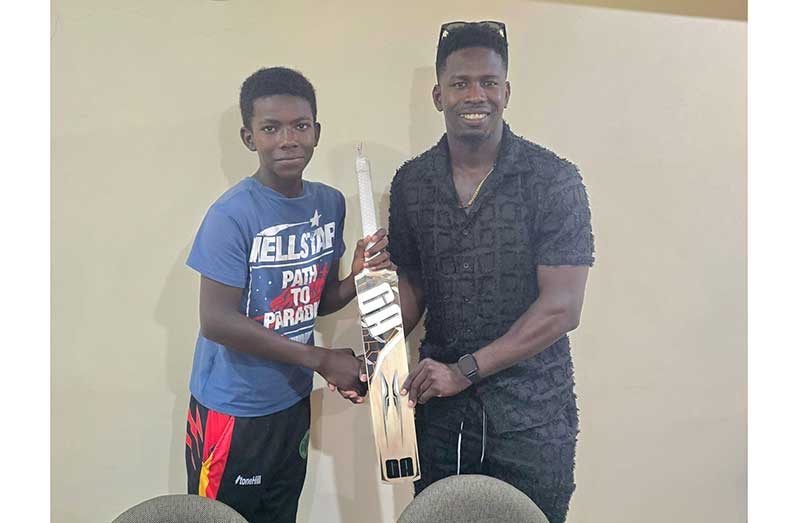 Adrain Emmanuel, left, receives the bat from Kevin Sinclair, right