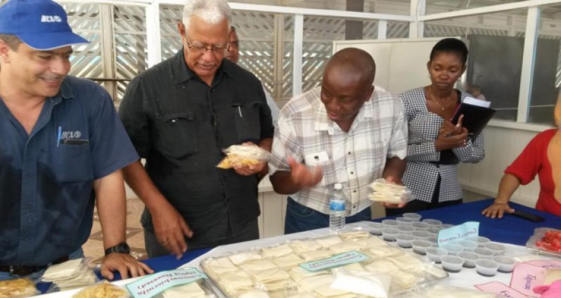 Minister of Agriculture Noel Holder, Permanent Secretary George Jervis and IICA representative Wilmot Garnett sample some of the products of the Tapakuma facility during the re-commissioning