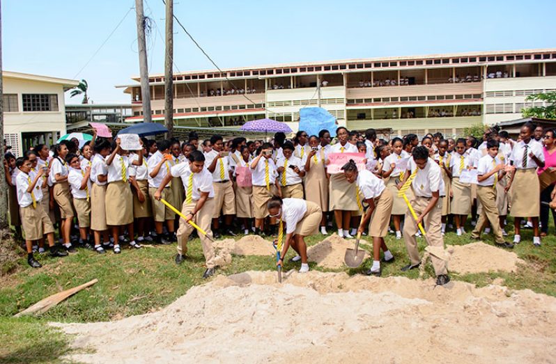 Queen’s College Agricultural Science students try to remove the sand that contractors dumped on the land, while other members of the student population, teachers and PTA members protest the partial demolition of the agricultural plot.