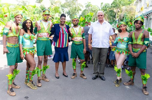 Minister Noel holder and Junior Minister, Valerie Yearwood pose with the revellers displaying the ministry’s costume (DPI photo)