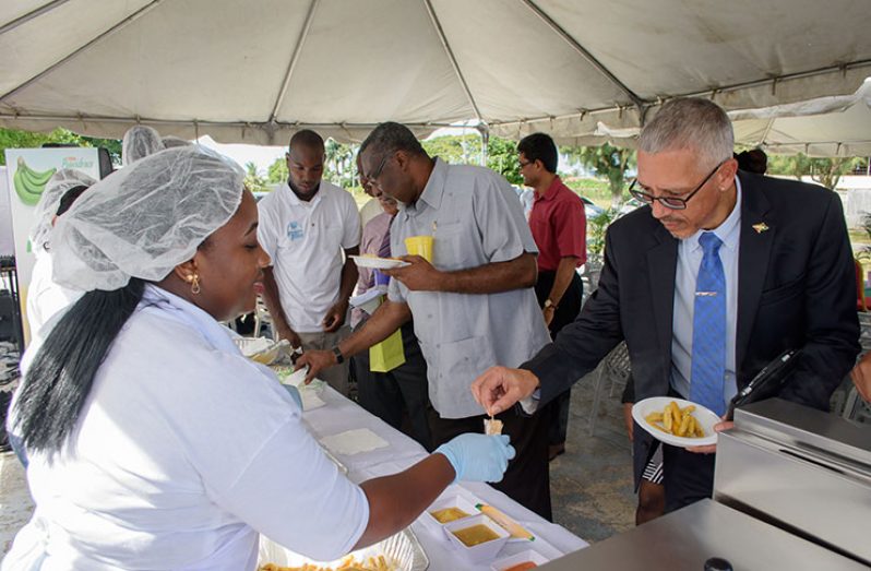 Business Minister Dominic Gaskin samples the locally produced Plantain Fries