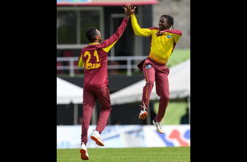 Akeal Hosein (left) and Hayden Walsh celebrate a wicket during yesterday’s first Twenty20 International. (Photo courtesy CWI Media)