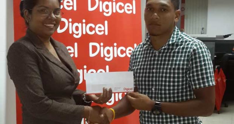 Alanzo Greaves is seen receiving cheque from Communications Manager, Vidya Sanichara.