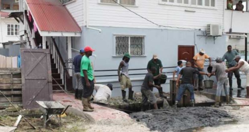 Residents use buckets to desilt drains in Alberttown as they embark on a major cleanup campaign