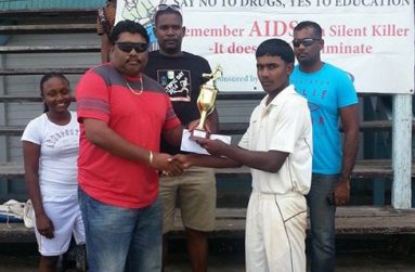 Well done, skipper! The successful Albion Community Centre Cricket Club Under-17 skipper Joshua Harrichand proudly accepts the 2013 BCB/Tenelec Inc. Under-17 championship trophy from first vice-president of the BCB Anil Beharry.