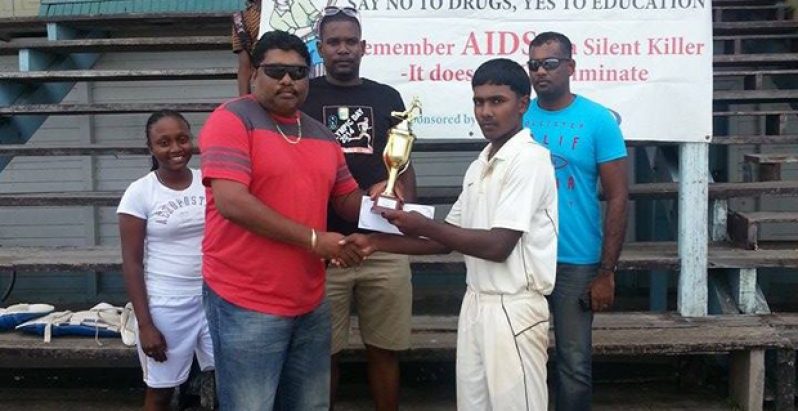 Well done, skipper! The successful Albion Community Centre Cricket Club Under-17 skipper Joshua Harrichand proudly accepts the 2013 BCB/Tenelec Inc. Under-17 championship trophy from first vice-president of the BCB Anil Beharry.