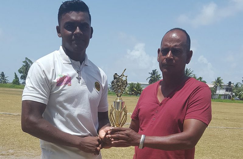 Alex Algu collects his man-of-the-match trophy from Chairman of GCB junior selectors,Nazimul Drepaul.