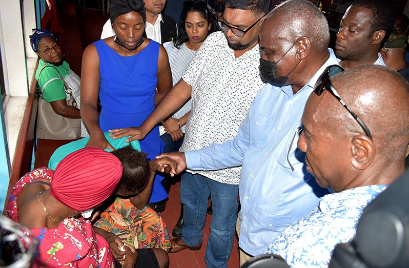 President Dr. Irfaan Ali along with members of his Cabinet comforting Tracy Flur, the mother who lost her three children in an early morning blaze at their Lot 10 Field Barnwell house, located aback Mocha on the East Bank of Demerara (ECD) (Elvin Croker photo)