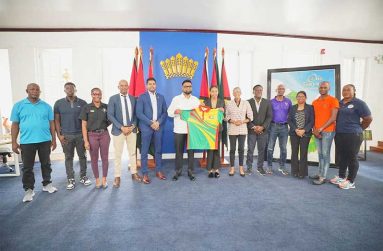 President Irfaan Ali displays the Olympic uniform with Olympian Chelsea Edghill and members of the Guyana Olympic Association (GOA) and Ministry of Culture, Youth and Sport