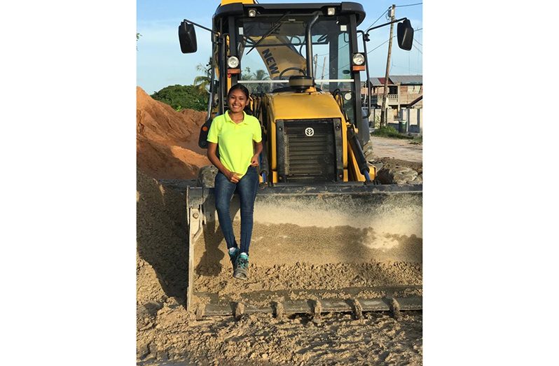 Alicia Duggin sits on a front loader backhoe, heavy-duty equipment that she is qualified to operate