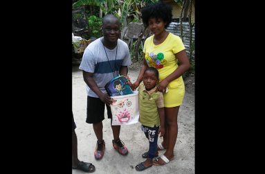 Nurse Colwyn Allen presenting a child
and his mother with school supplies
during one of the club’s many outreaches