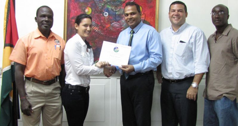 Alysa Xavier (second left) accepts the Pan American Hockey Federation certificate from Minister of Sport Dr Frank Anthony, while the others in picture, from left, GOA representative Deion Nurse, GHB president Philip Fernandes and GHB vice-president Ivor Thompson look on.