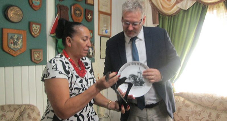 EU Ambassador Jernej Videti looks at a portrait of City Hall on a plaque that was given to him as a gift by the Mayoress