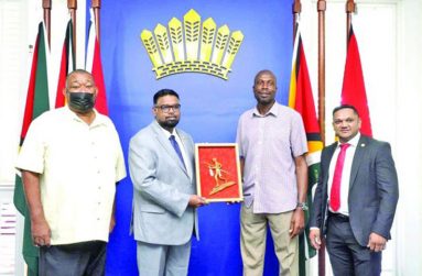 President Dr. Irfaan Ali and Sir Curtly Ambrose (centre) alongside BCB president Hilbert Foster (left) and Minister Vickram Bharrat (right)