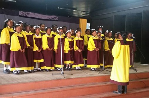 The Amelia’s Ward Primary School Choir in action at a recent competition at Linden’s Lichas Hall. Taking them through their paces, in the foreground, is Ms Jedidah Wilkinson