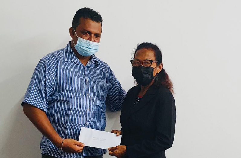 Regional Executive Officer (REO) Devanand Ramdatt presenting the grant to Toshao Yvonne Fredericks of Mainstay/Whyaka