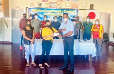 Henna Rupnarine, niece of Andrew Gonsalves, hands over the sponsorship cheque to ACCC president Vemen Walter, in the presence of other members of the club. (News Room picture)