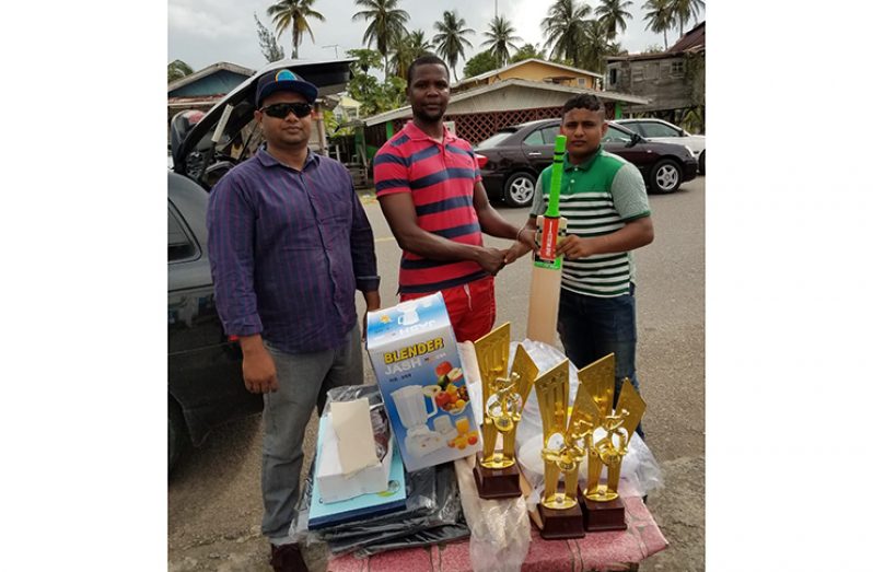 Guyana U-19 cricketer and National footballer Clive Andries collects the donation from RHTYSC’s Simon Naidu, while Mark Papannah shares the moment.