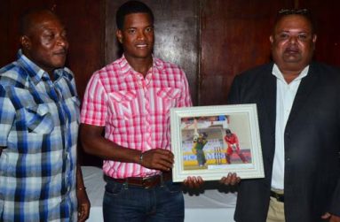 Georgetown Cricket Club’s head coach Montey Lynch (at left) shares the moment as the club’s latest West Indies Test player Leon Johnson (centre) hands over the framed picture which will be hung on the walls of the Club’s Hall of Fame, to Club president Lionel Jaikarran. (Photo by Adrian Narine)