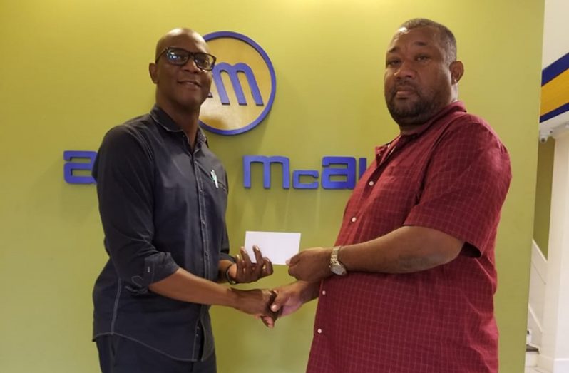 Human Resources Manager Mr Sheldon Hazelwood hands over sponsorship to RHTYSC Secretary Hilbert Foster.