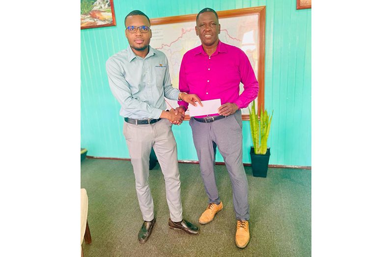 ANSA McAL Trading Bartica Branch Manager, Mr. Akeem Prowell (left) hands over the cheque to Easter Regatta Committee Chairman, Kenneth Williams.