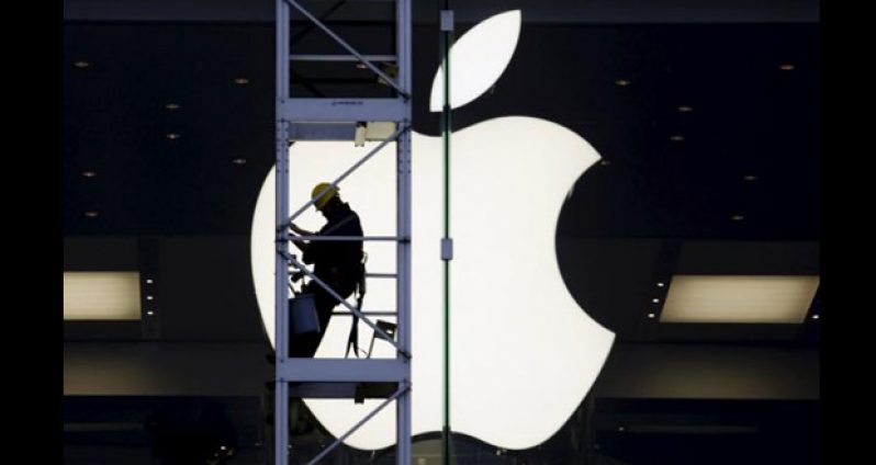 A worker climbs outside an Apple store in Hong Kong, China, in this April 10, 2013 file photo. REUTERS/BOBBY YIP/FILES