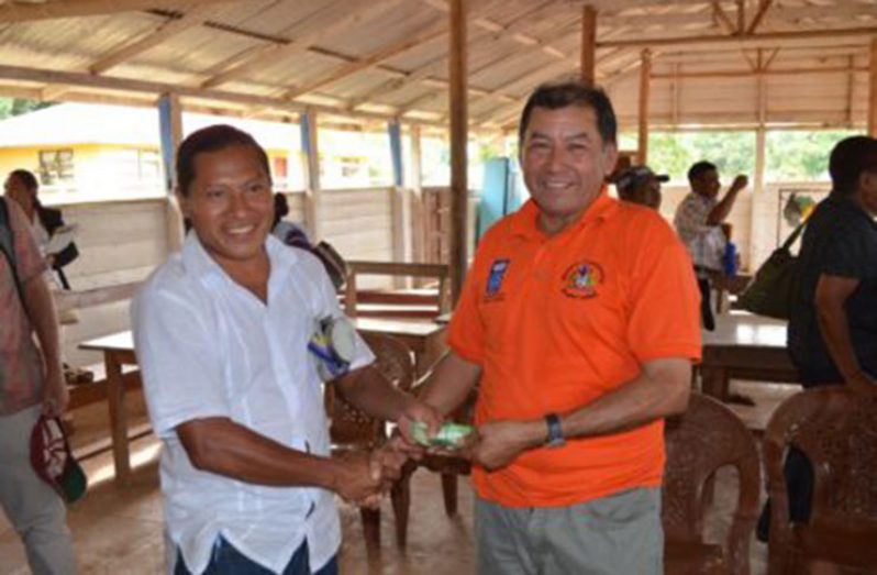 Minister of Indigenous Peoples’ Affairs, Sydney Allicock, handing over the money to Treasurer of NRDDB, Lakeram Haynes