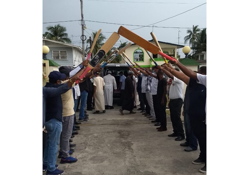 Softball cricketers in a display of love and unity form an arch at the Ogle Masjid.