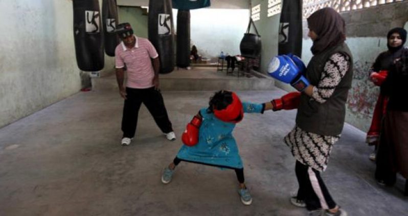 Arisha, 9, punches Misbah during an exercise session at the first women's boxing coaching camp in Karachi, Pakistan, February 20, 2016. (Reuters/Akhtar Soomro)