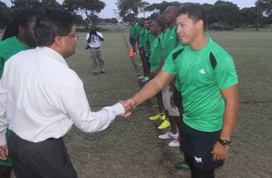 Finance Minister Dr Ashni Singh greets National 7s Rugby captain Ryan Gonsalves yesterday at the National Park Rugby field. (Sonell Nelson photo)