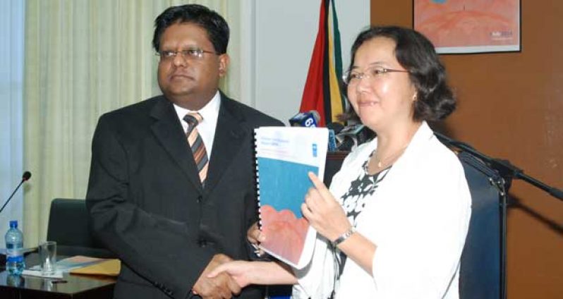 Minister of Finance, Dr. Ashni Singh, officially receives the 2014 Human Development report from Resident Representative, UNDP, Chisa Mikami