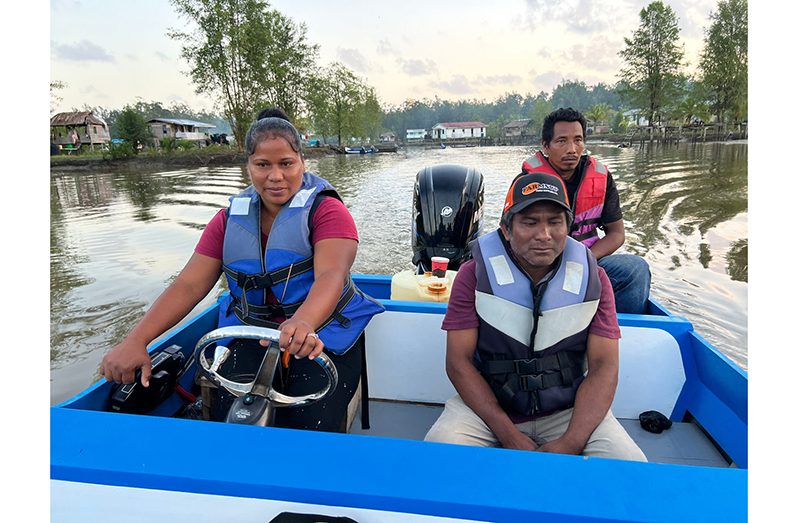 At the wheel, Madulina Harris with passengers in the boat on the Barima River