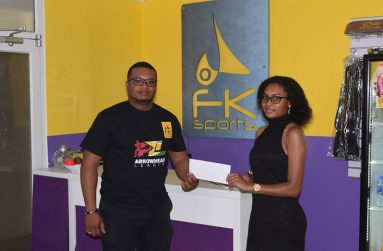 Store Manager of FK Sports, Ava Bamfield hands over sponsorship cheque to organiser Treiston Joseph at the store’s Garnett Street location.