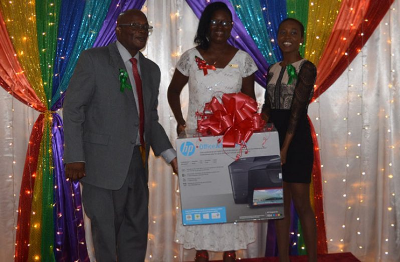 Coordinator of the University of Guyana’s Bachelors of Science Nursing Programme, Afesha Leacock-Marshall, presents the Dean of the Faculty of Health Sciences, Dr. Emanuel Cummings with the donation in the presence of another graduate, Regan Goppy.