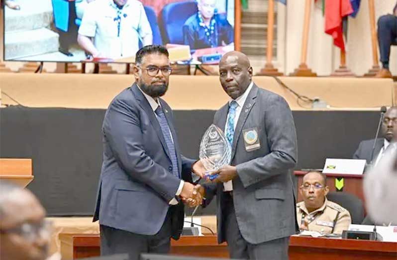 President, Dr Irfaan Ali receives a plaque from ACCP President Atlee Rodney in recognition of his robust leadership, during the opening ceremony of the 39th Association of Caribbean Commissioners of Police Conference