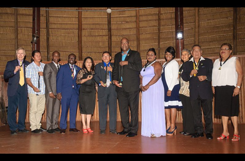 Minister of Indigenous People’s Affairs Sydney Allicock (sixth from left) and founder and President of iChange Nations, Dr Clyde Rivers (sixth from right) pose with recipients of the Sydney Allicock Global Humanitarian Award at the Umana Yana on Saturday  (Delano Williams photo)