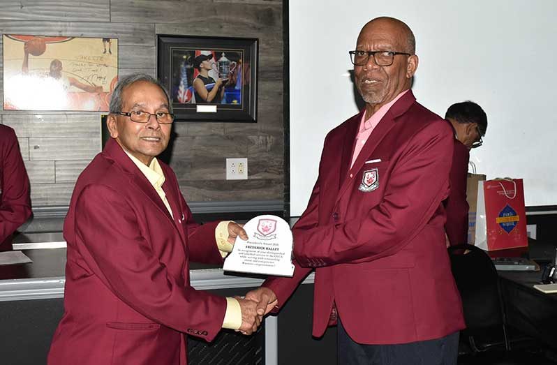 Assistant Secretary/Treasurer/PRO, Frederick Halley, right receives the President’s Award from CCUA President Azad Khan