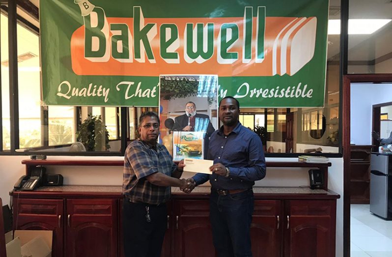 General Manager of Bakewell, Rajin Ganga presents the sponsorship cheque to GFF President, Wayne Forde.