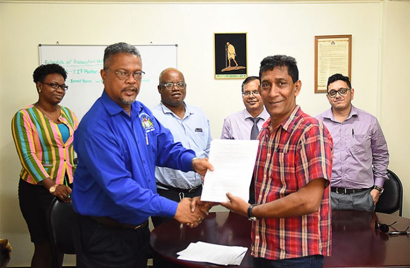 Chief Labour Officer, Charles Ogle (left) seals the three-year labour agreement in handshake with representative of the bank’s workers, Naresh Persaud  (Samuel Maughn photo)