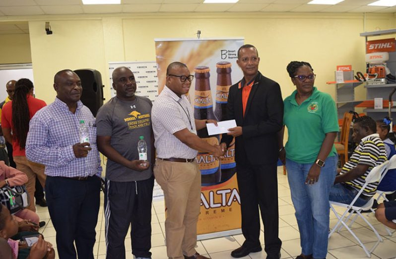 AAG president Aubrey Hutson (second from right) receives sponsorship cheque from Banks DIH representative in the presence of other officials.