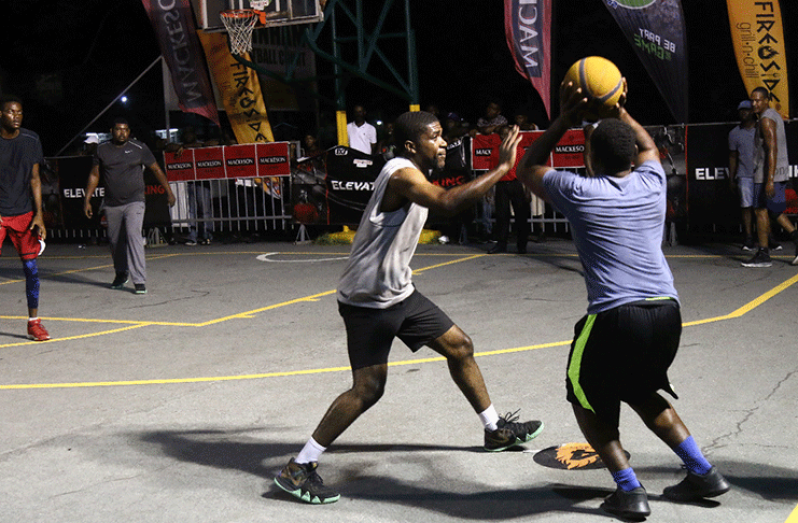 Dave Causeway about to drain a 4-point shot over Flame Throwers’ Michael Richards on the opening night of the Rawle Toney/Mackeson 3X3 Basketball Classic.