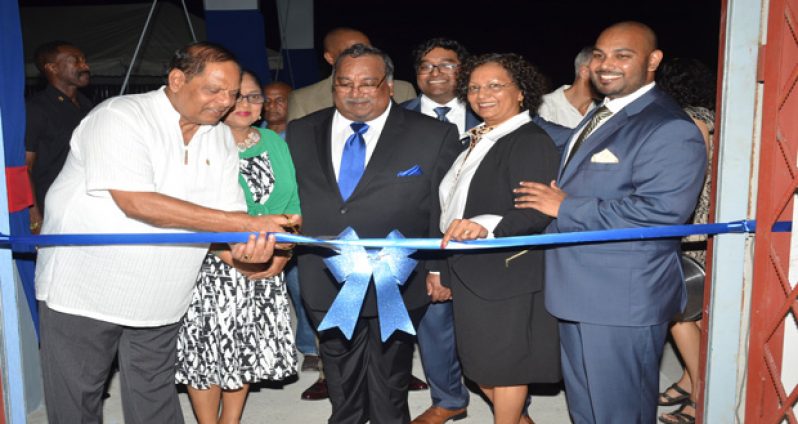 Acting President Moses Nagamootoo cuts the ceremonial ribbon Saturday to officially declare the new Beepats warehouse open