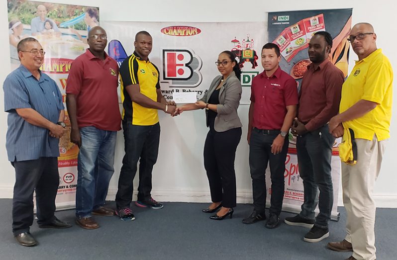 Edward B Beharry & Company Limited Brand Manager Monique Tiwari (fourth from right) hands over her company’s $1.5M cheque to ‘Green Machine’ captain Dwayne Schroeder, in the company of other GRFU representatives. (Rawle Toney photo)