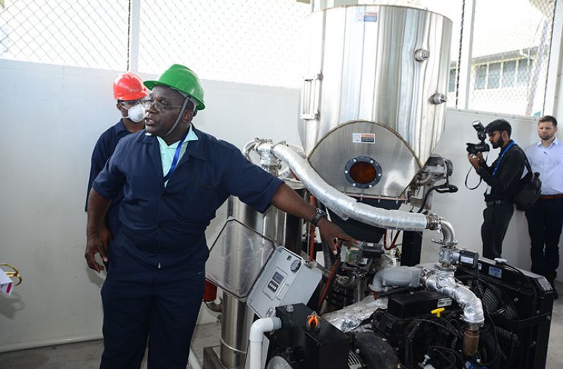 Researcher in the Faculty of Agriculture and Forestry and project team leader, Dr. Lawrence Lewis demonstrates how the bioenergy gasifier operates (Samuel Maughn photo)