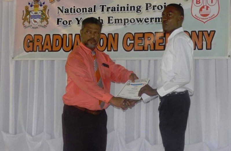 A graduate receiving his certificate from Charles Ogle, Chief Labour, Occupational Safety and Health Officer at the Ministry of Social Protection