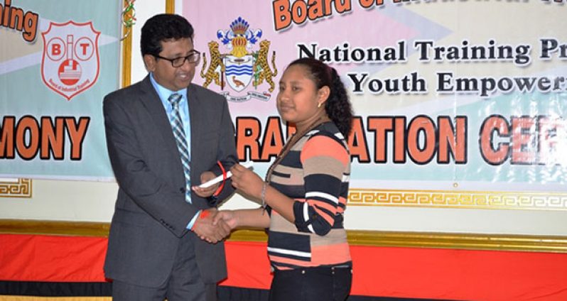 Attorney General, Anil Nandlall presenting one of the graduands with her certificate of achievement