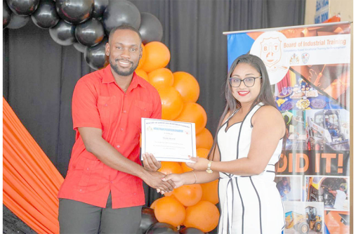 BIT Minister of Labour and Manpower Planning, Keoma Griffith, presents one of the many graduands with a certificate