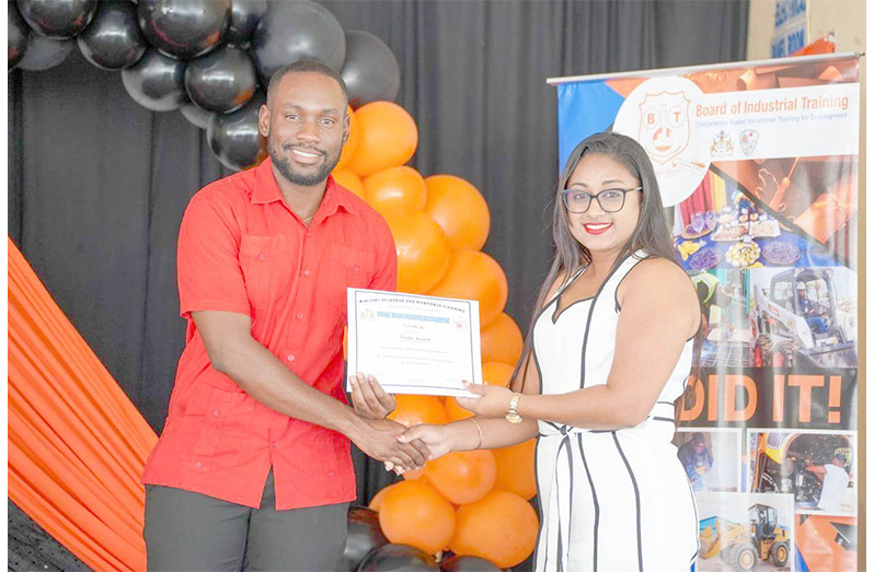 BIT Minister of Labour and Manpower Planning, Keoma Griffith, presents one of the many graduands with a certificate