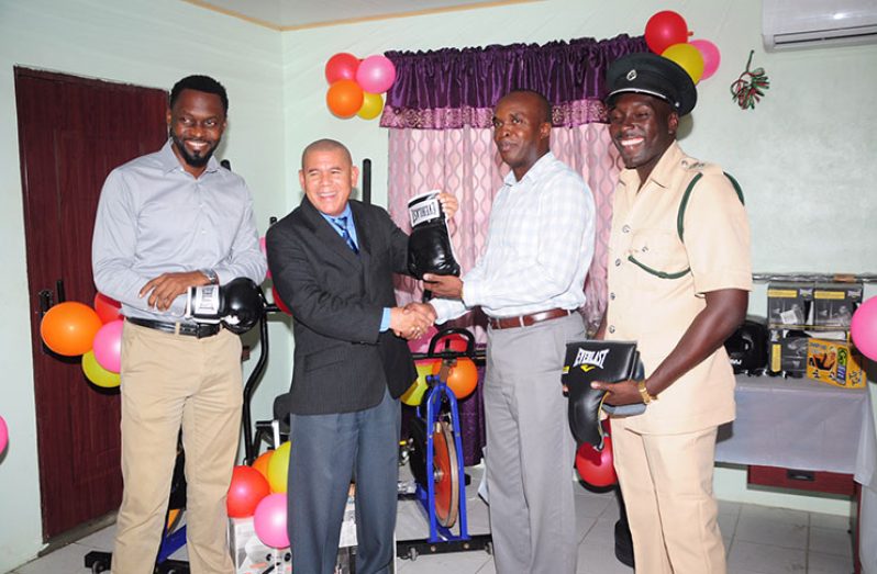 Minister of Social Cohesion, Dr George Norton, hands over the boxing equipment to Director of Prisons Gladwin Samuels, while Director of Sport Christopher Jones (left) and Senior Superintendent Kevin Pilgrim look on. (Delano Williams photos)