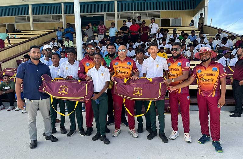 The members of the team pose with the students and their bags